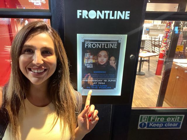 Haya Al Badarneh beside a Frontline Club screening poster.