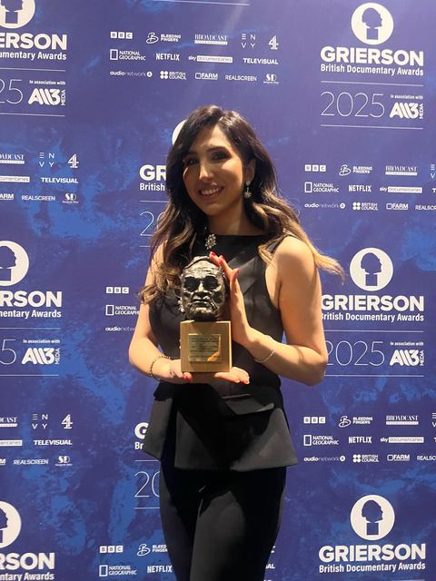 Haya Al Badarneh holding the Grierson Award.